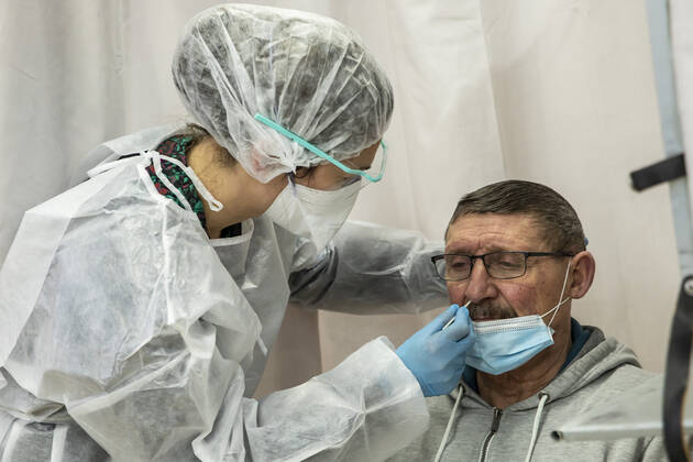 (210112) -- ROUBAIX, Jan. 12, 2021 -- A medical worker wearing protective equipment takes a swab sample from a man for a COVID-19 polymerase chain reaction (PCR) test during a mass COVID-19 testing operation in Roubaix, northern France, Jan. 11, 2021. A 6-day massive screening test for COVID-19 was organized in Roubaix from Monday. (Photo by Xinhua) FRANCE-ROUBAIX-COVID-19-MASS TESTING SebastienxCourdji 