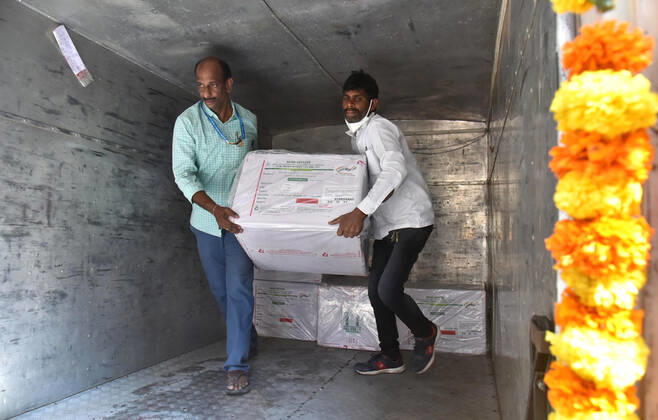 (210112) -- HYDERABAD, Jan. 12, 2021 -- Health workers carry a box containing COVID-19 vaccine from a refrigerated vehicle to a cold storage in Hyderabad, capital of India s southern state of Telengana, Jan. 12, 2021. India s federal government said that the COVID-19 vaccination drive will begin in the country on Jan. 16. The roll-out of COVID-19 vaccine will provide priority to the healthcare workers and the frontline workers who are estimated to be around 30 million. (Photo by Xinhua) INDIA-HYDERABAD-COVID-19-VACCINE ParthaxSarkar 
