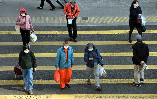 (210112) -- HONG KONG, Jan. 12, 2021 -- People wearing face masks walk across the street in south China s Hong Kong, Jan. 12, 2021. Hong Kong s Center for Health Protection (CHP) reported 60 additional confirmed cases of COVID-19 on Tuesday, taking its total tally to 9,343. All of the 60 new cases are local infections, with 13 of unknown origins. TO GO WITH Hong Kong reports 60 new COVID-19 cases, all local infections ) CHINA-HONG KONG-COVID-19-CASES (CN) LoxPingxFai