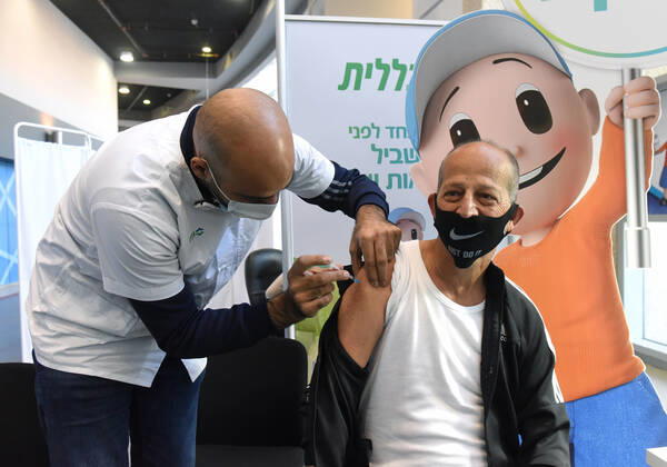 A man receives his second shot of the Pfizer- BioNTech COVID-19 vaccine in an Israeli vaccination center in Jerusalem, on Tuesday, January 12, 2021. Israel will expand the vaccination drive inoculating teachers and people over 50 years on Wednesday.  JER2021011208 DEBBIExHILL