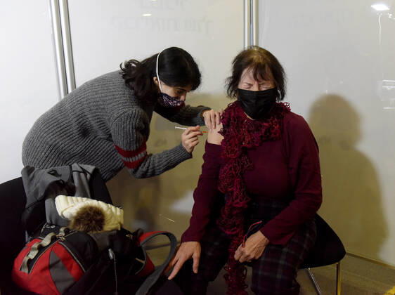 A woman receives the Pfizer- BioNTech COVID-19 vaccine in an Israeli vaccination center in Jerusalem, on Tuesday, January 12, 2021. Israel will expand the vaccination drive inoculating teachers and people over 50 years on Wednesday.  JER2021011214 DEBBIExHILL