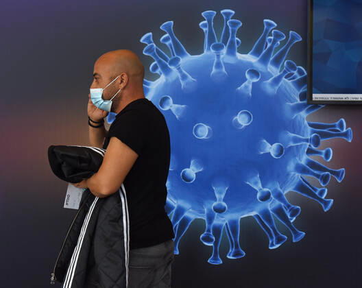 A man walks in an Israeli vaccination center in Jerusalem, on Tuesday, January 12, 2021. Israel will expand the vaccination drive inoculating teachers and people over 50 years on Wednesday.  JER2021011219 DEBBIExHILL