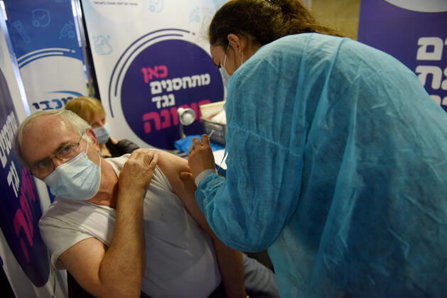 A man receives his second shot of the Pfizer- BioNTech COVID-19 vaccine in an Israeli vaccination center in Jerusalem, on Tuesday, January 12, 2021. Israel will expand the vaccination drive inoculating teachers and people over 50 years on Wednesday.  JER2021011220 DEBBIExHILL