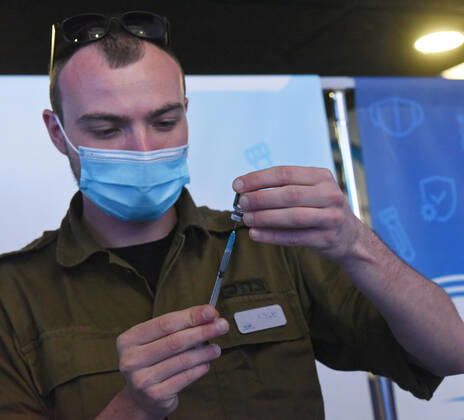 An Israeli soldier prepares the Pfizer- BioNTech COVID-19 vaccine in an Israeli vaccination center in Jerusalem, on Tuesday, January 12, 2021. Israel will expand the vaccination drive inoculating teachers and people over 50 years on Wednesday.  JER2021011221 DEBBIExHILL