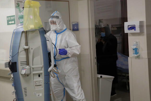 (210112) -- ASHKELON (ISRAEL), Jan. 12, 2021 -- Israeli medical staff wearing protective gear work in a COVID-19 isolation ward at Barzilai Medical Center in Ashkelon, southern Israel, on Jan. 12, 2021. Israel s Ministry of Health reported 9,242 new COVID-19 cases on Tuesday, bringing the total number in the country to 508,604. (Photo by Xinhua) ISRAEL-ASHKELON-COVID-19-CASES GilxCohenxMagen 