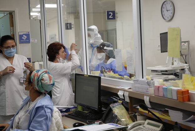(210112) -- ASHKELON (ISRAEL), Jan. 12, 2021 -- Israeli medical staff wearing protective gear work in a COVID-19 isolation ward at Barzilai Medical Center in Ashkelon, southern Israel, on Jan. 12, 2021. Israel s Ministry of Health reported 9,242 new COVID-19 cases on Tuesday, bringing the total number in the country to 508,604. (Photo by Xinhua) ISRAEL-ASHKELON-COVID-19-CASES GilxCohenxMagen 