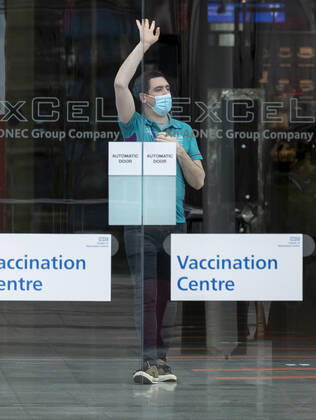 (210113) -- LONDON, Jan. 13, 2021 -- A staff wearing a face mask is seen in the Vaccination Centre at ExCel exhibition centre in London, Britain, Jan. 12, 2021. British Prime Minister Boris Johnson on Monday warned against false complacency as the country is seeking to speed up the coronavirus vaccine rollout. According to the prime minister, 2.4 million coronavirus jabs have been administered across Britain. Seven new mass vaccination sites in England opened Monday, as the country races against time to bring the pandemic under control. ) BRITAIN-LONDON-COVID-19-VACCINE ROLLOUT HanxYan 
