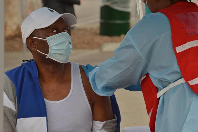 A resident is inoculated with the Moderna COVID-19 vaccine at the Balboa Sports Center vaccination site in Los Angeles on Tuesday, January 12, 2021. People aged 65 and older and those with serious.underlying health conditions in Los Angeles and across California could quickly become eligible for a COVID-19 vaccine, with federal officials urging states Tuesday to more widely distribute the shots.  LAP2021011211 JIMxRUYMEN