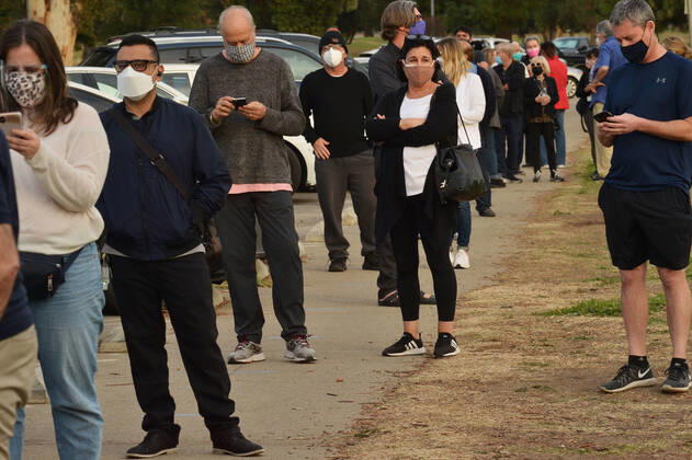 Residents wait in line to be inoculated with the Moderna COVID-19 vaccine at the Balboa Sports Center vaccination site in Los Angeles on Tuesday, January 12, 2021. People aged 65 and older and those with serious underlying health conditions in Los Angeles and across California could quickly become eligible for a COVID-19 vaccine, with federal officials urging states Tuesday to more widely distribute the shots.  LAP2021011212 JIMxRUYMEN