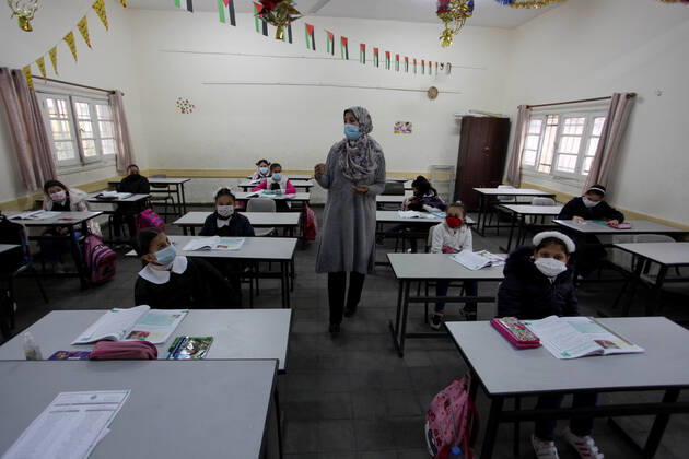 January 13, 2021, Gaza City, Gaza Strip, Palestinian Territory: Palestinian students wear protective face masks, listen to their teacher as schools gradually reopen amid the coronavirus disease (COVID-19) outbreak, at their school in Gaza city, on January 13, 2021. In a written statement, the Palestinian Health Ministry said 7 more people have died from the virus in the last 24 hours in Gaza strip and that 437 new cases have been identified Gaza City Palestinian Territory - ZUMAap3_ 20210113_zaf_ap3_015 Copyright: xMahmoudxAjjourx