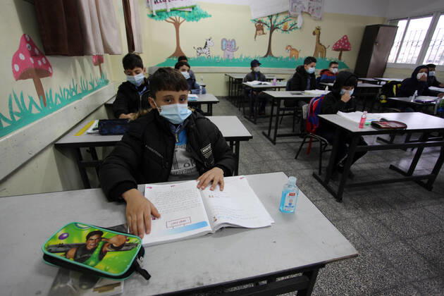 January 13, 2021, Gaza City, Gaza Strip, Palestinian Territory: Palestinian students wear protective face masks, listen to their teacher as schools gradually reopen amid the coronavirus disease (COVID-19) outbreak, at their school in Gaza city, on January 13, 2021. In a written statement, the Palestinian Health Ministry said 7 more people have died from the virus in the last 24 hours in Gaza strip and that 437 new cases have been identified Gaza City Palestinian Territory - ZUMAap3_ 20210113_zaf_ap3_020 Copyright: xMahmoudxAjjourx