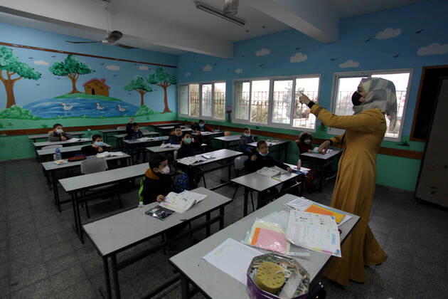 January 13, 2021, Gaza City, Gaza Strip, Palestinian Territory: Palestinian students wear protective face masks, listen to their teacher as schools gradually reopen amid the coronavirus disease (COVID-19) outbreak, at their school in Gaza city, on January 13, 2021. In a written statement, the Palestinian Health Ministry said 7 more people have died from the virus in the last 24 hours in Gaza strip and that 437 new cases have been identified Gaza City Palestinian Territory - ZUMAap3_ 20210113_zaf_ap3_028 Copyright: xMahmoudxAjjourx