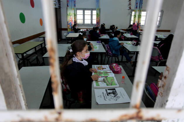 January 13, 2021, Gaza City, Gaza Strip, Palestinian Territory: Palestinian students wear protective face masks, listen to their teacher as schools gradually reopen amid the coronavirus disease (COVID-19) outbreak, at their school in Gaza city, on January 13, 2021. In a written statement, the Palestinian Health Ministry said 7 more people have died from the virus in the last 24 hours in Gaza strip and that 437 new cases have been identified Gaza City Palestinian Territory - ZUMAap3_ 20210113_zaf_ap3_032 Copyright: xMahmoudxAjjourx