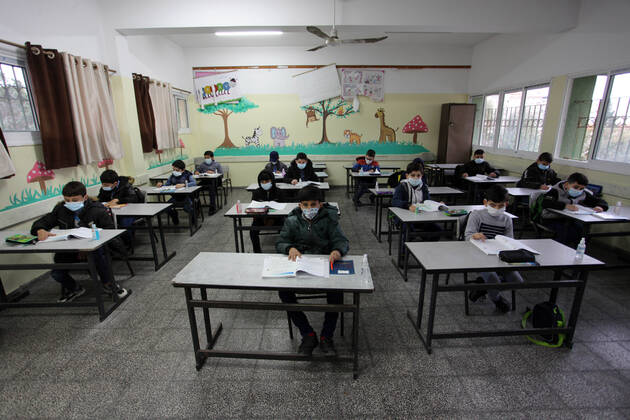 January 13, 2021, Gaza City, Gaza Strip, Palestinian Territory: Palestinian students wear protective face masks, listen to their teacher as schools gradually reopen amid the coronavirus disease (COVID-19) outbreak, at their school in Gaza city, on January 13, 2021. In a written statement, the Palestinian Health Ministry said 7 more people have died from the virus in the last 24 hours in Gaza strip and that 437 new cases have been identified Gaza City Palestinian Territory - ZUMAap3_ 20210113_zaf_ap3_034 Copyright: xMahmoudxAjjourx