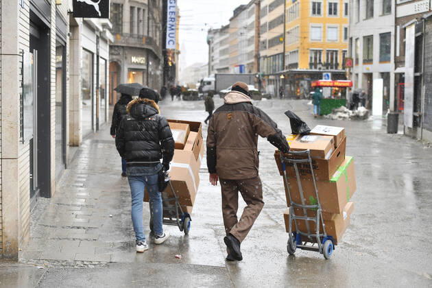 UPS Paketzusteller bei der Arbeit,Paketbote,United Parcel in Innenstadt in Muenchen.Zustellung in der Innenstadt,Fussgaengerzone in Muenchen am 12.01.2021. Service,Paket,Pakete,Paketdienst,liefern,zustellen, entladen,versenden,Transporter,Sackkarre.