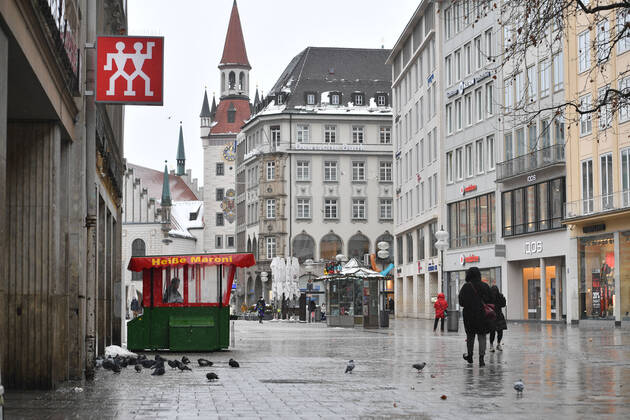 Themenbild Winter in der Coronavirus Pandemie. Verlaengerung Lockdown bis 31.Januar 2021. Leere Strassen und Plaetze.Nur wenige Passanten gehen ueber den Marienplatz in Muenchen am 12.01.2021. An einem Heisse Maroni Stand tummeln sich Tauben. Personen,Passanten.