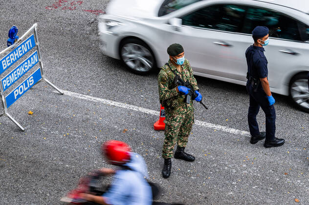 (210113) -- KUALA LUMPUR, Jan. 13, 2021 -- A policeman and a soldier are seen at a check point in Kuala Lumpur, Malaysia, Jan. 13, 2021. Malaysia announced tightening movement restriction measures to contain the spread of COVID-19 for two weeks starting from Wednesday, citing the country s health care system being at a breaking point. ) MALAYSIA-KUALA LUMPUR-COVID-19-MOVEMENT RESTRICTIONS ZhuxWei 