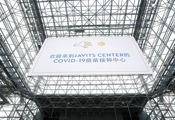 Signs for COVID-19 Vaccintaion are set up around the inside as patients arrive and go through the check in process to received a COVID-19 vaccination at the Jacob K. Javits Convention Center in New York City on Wednesday, January 13, 2021. The Javits Convention Center which served as a massive field hospital last spring when New York City was the epicenter of the pandemic, now will serve as a huge vaccine distribution center.  NYP20210113115 JohnxAngelillo