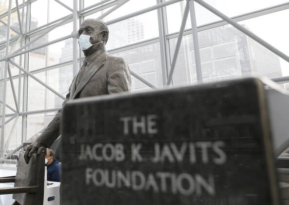 A face mask is on a statue of Jacob K. Javits as patients arrive and go through the check in process to received a COVID-19 vaccination at the Jacob K. Javits Convention Center in New York City on Wednesday, January 13, 2021. The Javits Convention Center which served as a massive field hospital last spring when New York City was the epicenter of the pandemic, now will serve as a huge vaccine distribution center.  NYP20210113121 JohnxAngelillo