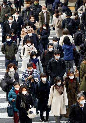 Day after Japan expands coronavirus emergency to 7 more prefectures People wearing face masks walk in Osaka s Umeda area on Jan. 14, 2021. Japanese Prime Minister Yoshihide Suga declared a state of emergency in seven additional prefectures, including Osaka, the previous day amid the continued spread of the novel coronavirus. 