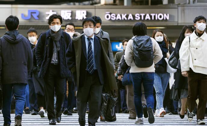 Day after Japan expands coronavirus emergency to 7 more prefectures People wearing face masks walk in Osaka s Umeda area on Jan. 14, 2021. Prime Minister Yoshihide Suga declared a state of emergency in seven additional prefectures, including Osaka, the previous day amid the continued spread of the novel coronavirus. 