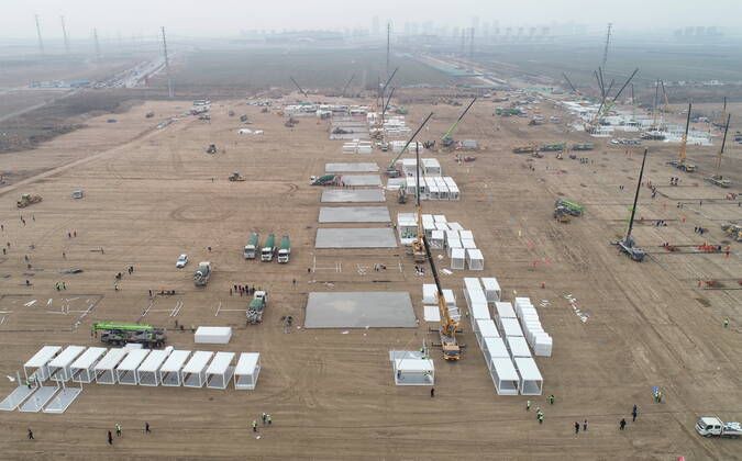 (210114) -- SHIJIAZHUANG, Jan. 14, 2021 -- Aerial photo taken on Jan. 14, 2021 shows the construction site of a centralized medical observation center in Shijiazhuang, capital of north China s Hebei Province. Construction workers on Wednesday started building a centralized medical observation center in Shijiazhuang, capital of north China s Hebei Province, where clustered COVID-19 cases occurred. The isolation center will likely cover 33 hectares of area near a village in Zhengding County, Shijiazhuang. Three integrated housing producers in Tangshan City, Hebei, have been entrusted to produce 3,000 makeshift wards for the center. Each ward has a space of 18 square meters. ) CHINA-HEBEI-SHIJIAZHUANG-COVID-19-ISOLATION CENTER-CONSTRUC