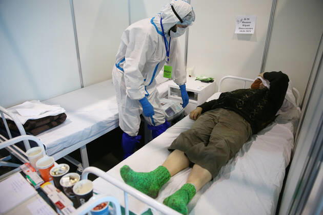 ST PETERSBURG, RUSSIA - JANUARY 14, 2021: A medical worker is seen by a patient in the Red Zone of a temporary infectious diseases hospital that treats COVID-19 patients at the Lenexpo Exhibition Complex. Peter Kovalev TASS  TS0F4264