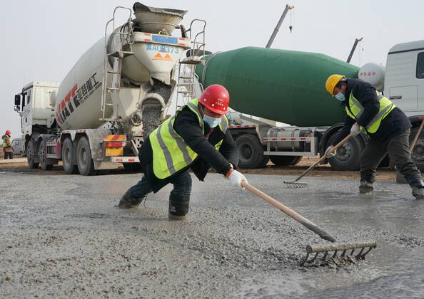 (210114) -- SHIJIAZHUANG, Jan. 14, 2021 -- Workers harden the road surface on the construction site of a centralized medical observation center in Shijiazhuang, capital of north China s Hebei Province, Jan. 14, 2021. Construction workers on Wednesday started building a centralized medical observation center in Shijiazhuang, capital of north China s Hebei Province, where clustered COVID-19 cases occurred. The isolation center will likely cover 33 hectares of area near a village in Zhengding County, Shijiazhuang. Three integrated housing producers in Tangshan City, Hebei, have been entrusted to produce 3,000 makeshift wards for the center. Each ward has a space of 18 square meters. ) CHINA-HEBEI-SHIJIAZHUANG-COVID-19-ISOLATION CENTER-