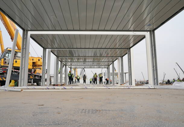 (210114) -- SHIJIAZHUANG, Jan. 14, 2021 -- Workers put up prefabs on the construction site of a centralized medical observation center in Shijiazhuang, capital of north China s Hebei Province, Jan. 14, 2021. Construction workers on Wednesday started building a centralized medical observation center in Shijiazhuang, capital of north China s Hebei Province, where clustered COVID-19 cases occurred. The isolation center will likely cover 33 hectares of area near a village in Zhengding County, Shijiazhuang. Three integrated housing producers in Tangshan City, Hebei, have been entrusted to produce 3,000 makeshift wards for the center. Each ward has a space of 18 square meters. ) CHINA-HEBEI-SHIJIAZHUANG-COVID-19-ISOLATION CENTER-CONSTRUCT