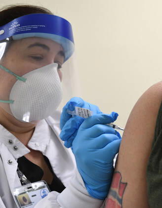 January 14, 2021, Racine, Wisconsin, USA: RN GINA BREHM gives the first of the first 70 doses of 140 doses of the Pfizer COVID-19 vaccine received for City of Racine firefighters as they are administered Thursday January 14, 2021 to FIREFIGHTER WILLIAM WALMSLEY at the city health department in City Hall. The remaining doses will be administered Friday. Racine USA - ZUMAh154 20210114_znp_h154_010 Copyright: xMarkxHertzbergx