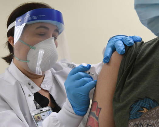 January 14, 2021, Racine, Wisconsin, USA: RN GINA BREHM gives the first of the first 70 doses of 140 doses of the Pfizer COVID-19 vaccine received for City of Racine firefighters as they are administered Thursday January 14, 2021 to FIREFIGHTER WILLIAM WALMSLEY at the city health department in City Hall. The remaining doses will be administered Friday. Racine USA - ZUMAh154 20210114_znp_h154_011 Copyright: xMarkxHertzbergx