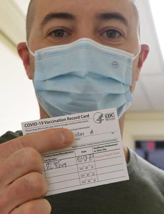 January 14, 2021, Racine, Wisconsin, USA: FIREFIGHTER WILLIAM WALMSLEY shows his proof of vaccination after being given the first of the first 70 doses of 140 doses of the Pfizer COVID-19 vaccine received for City of Racine firefighters administered Thursday January 14, 2021 to at the city health department in City Hall. The remaining doses will be administered Friday. Racine USA - ZUMAh154 20210114_znp_h154_012 Copyright: xMarkxHertzbergx