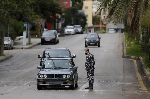 (210114) -- BEIRUT, Jan. 14, 2021 -- A policeman checks a car on a street during a lockdown in Beirut, Lebanon, on Jan. 14, 2021. Lebanon s Higher Defense Council declared a state of emergency between Jan. 14-25 that includes a total lockdown in hope to restrict further spread of COVID-19, Al-Jadeed local TV channel reported. ) LEBANON-BEIRUT-COVID-19-LOCKDOWN BilalxJawich 