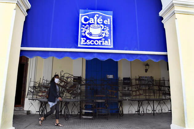 (210115) -- HAVANA, Jan. 15, 2021 -- A woman wearing a face mask walks past a closed cafe in Havana, Cuba, Jan. 14, 2021. Local government in Havana announced new restrictive measures in response to the COVID-19 pandemic as 550 new cases were logged nationwide on Wednesday, setting a new daily record for the sixth day in a row. (Photo by Xinhua) CUBA-HAVANA-COVID-19-CASES JoaquinxHernandez 