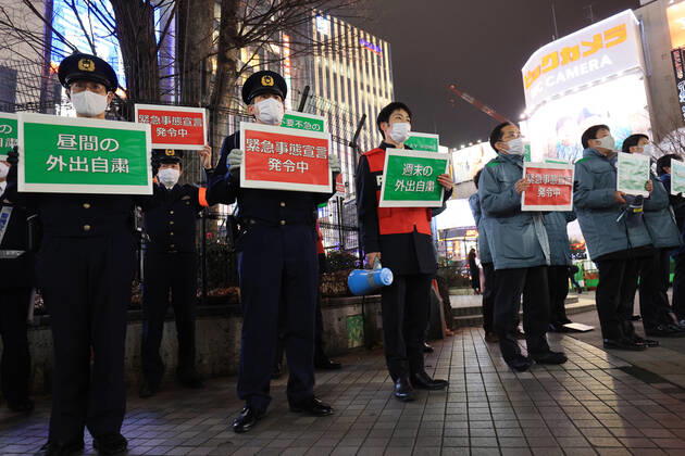 January 15, 2018, Tokyo, Japan - Local government officers and police officers hold placards and ask people to stay home at Shinjuku entertainment district amid outbreak of the new coronavirus in Tokyo on Friday, January 15, 2021. Japanese government declared a state of emergency on Tokyo and 10 other prefectures this week and requested nightclubs and restaurants to close 8 pm.  (152049265)