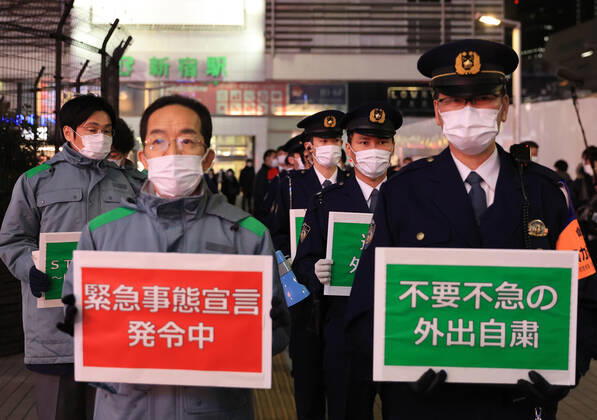 January 15, 2018, Tokyo, Japan - Local government officers and police officers hold placards and ask people to stay home at Shinjuku entertainment district amid outbreak of the new coronavirus in Tokyo on Friday, January 15, 2021. Japanese government declared a state of emergency on Tokyo and 10 other prefectures this week and requested nightclubs and restaurants to close 8 pm.  (152049268)