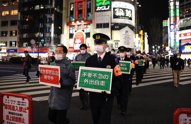January 15, 2018, Tokyo, Japan - Local government officers and police officers hold placards and ask people to stay home at Shinjuku entertainment district amid outbreak of the new coronavirus in Tokyo on Friday, January 15, 2021. Japanese government declared a state of emergency on Tokyo and 10 other prefectures this week and requested nightclubs and restaurants to close 8 pm.  (152049272)