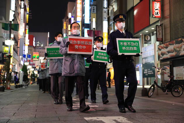 January 15, 2018, Tokyo, Japan - Local government officers and police officers hold placards and ask people to stay home at Shinjuku entertainment district amid outbreak of the new coronavirus in Tokyo on Friday, January 15, 2021. Japanese government declared a state of emergency on Tokyo and 10 other prefectures this week and requested nightclubs and restaurants to close 8 pm.  (152049275)