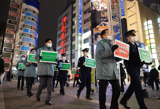 January 15, 2018, Tokyo, Japan - Local government officers and police officers hold placards and ask people to stay home at Shinjuku entertainment district amid outbreak of the new coronavirus in Tokyo on Friday, January 15, 2021. Japanese government declared a state of emergency on Tokyo and 10 other prefectures this week and requested nightclubs and restaurants to close 8 pm.  (152049276)