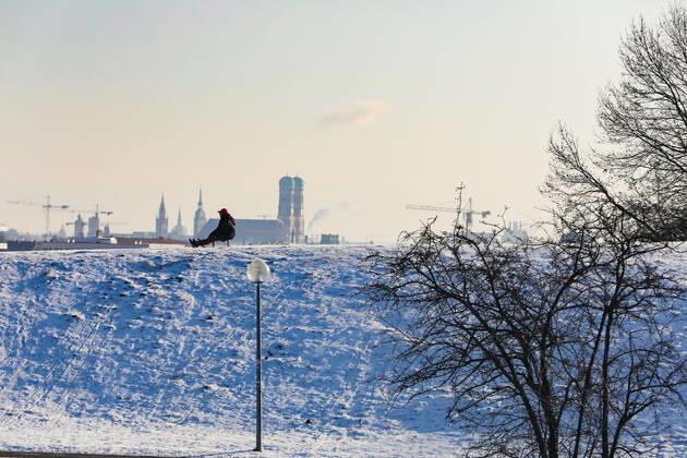 Freizeitaktivitäten im Olympiapark 15.01.2021 MÜNCHEN Schlittenfahrer auf dem Olympiaberg - Im Hintergrund die Skyline von München, inklusive Frauenkirche. München Bayern Deutschland