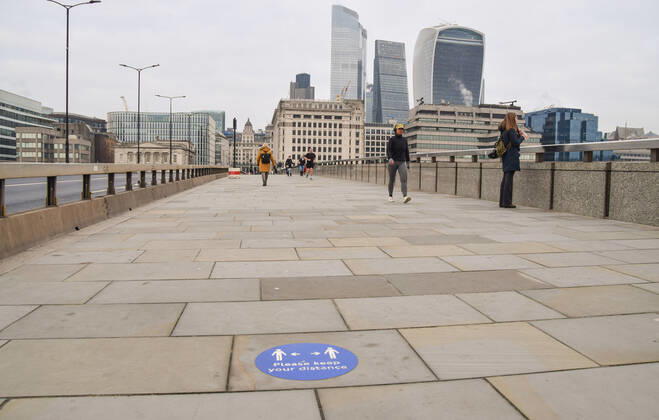 January 15, 2021, London, United Kingdom: People walk past a social distancing sign on London Bridge..England remains under lockdown as the government battles to keep the coronavirus pandemic under control. London United Kingdom - ZUMAs197 20210115_zab_s197_004 Copyright: xVukxValcicx
