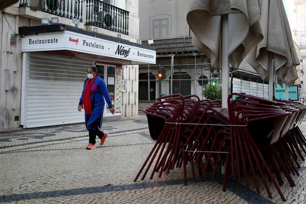 January 15, 2021, Lisbon, Portugal: A woman wearing a face mask walks by a closed restaurant on the first day of the second national lockdown to combat the COVID-19 Coronavirus pandemic in Lisbon, Portugal on January 15, 2021. Portuguese Prime Minister Antonio Costa announced last Wednesday a new confinement between January 15 and 30 with the same restrictive measures of March and April 2020, with the only relevant new exception that is schools will remain in full operation. Lisbon Portugal - ZUMAf123 20210115_zap_f123_018 Copyright: xPedroxFiuzax