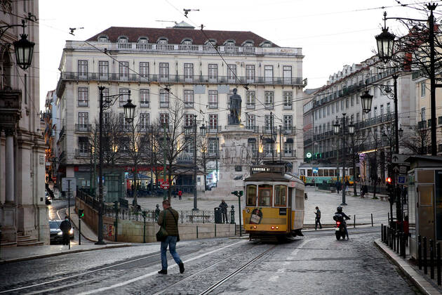 January 15, 2021, Lisbon, Portugal: A man crosses a street past a tram on the first day of the second national lockdown to combat the COVID-19 Coronavirus pandemic in Lisbon, Portugal on January 15, 2021. Portuguese Prime Minister Antonio Costa announced last Wednesday a new confinement between January 15 and 30 with the same restrictive measures of March and April 2020, with the only relevant new exception that is schools will remain in full operation. Lisbon Portugal - ZUMAf123 20210115_zap_f123_021 Copyright: xPedroxFiuzax