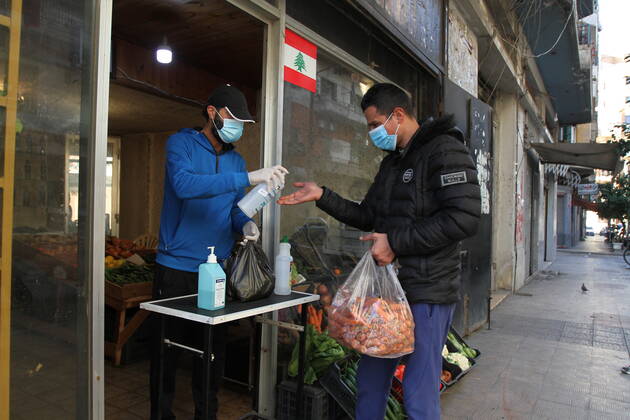 (210115) -- TRIPOLI (LEBANON), Jan. 15, 2021 -- A vegetable storekeeper sanitizes a customer s hand during a total lockdown in Tripoli, Lebanon, on Jan. 15, 2021. Lebanon registered on Friday 6,154 new COVID-19 cases, the highest daily increase in the country, raising the tally to 243,286, the Health Ministry reported. The death toll from the virus went up by 44 to 1,825, it added. (Photo by Xinhua) LEBANON-TRIPOLI-COVID-19-CASES Khaled