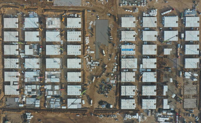 (210116) -- SHIJIAZHUANG, Jan. 16, 2021 -- Aerial photo taken on Jan. 16, 2021 shows the construction site of a centralized medical observation center in Shijiazhuang, capital of north China s Hebei Province. As part of the measures to cope with the recent COVID-19 resurgence, authorities in Shijiazhuang have rushed to build a new isolation center with a designed capacity of 3,000 rooms in Zhengding County. Close contacts and sub-close contacts of confirmed COVID-19 patients will be placed under medical observation in the new center, which will cover a total area of about 33.3 hectares, according to the housing and urban-rural development bureau of Shijiazhuang. With an area of 18 square meters, each room will be equipped with faci 