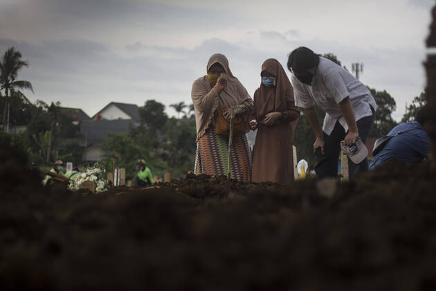 January 16, 2021, Jakarta, DKI Jakarta, Indonesia: A Family reacts next to a grave during attending the funeral of their relatives who died of coronavirus at a cemetry amid the coronavirus emergency in Jakarta, Indonesia Jakarta Indonesia - ZUMAz107 20210116_zip_z107_004 Copyright: xMuhammadxZaenuddinx