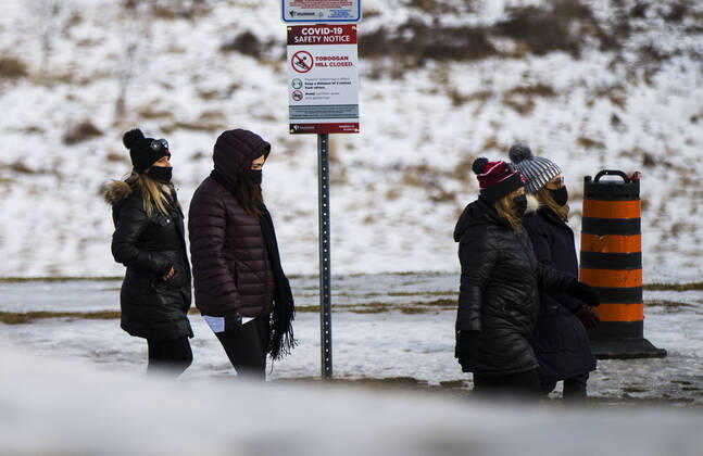 (210116) -- ONTARIO, Jan. 16, 2021 -- People wearing face masks walk past a closed toboggan hill in Vaughan, Ontario, Canada, on Jan. 16, 2021. Canada s COVID-19 cases surpassed 700,000 on Saturday morning, with the total hitting 700,988, including 17,847 deaths, according to CTV. (Photo by Xinhua) CANADA-ONTARIO-COVID-19-CASES ZouxZheng