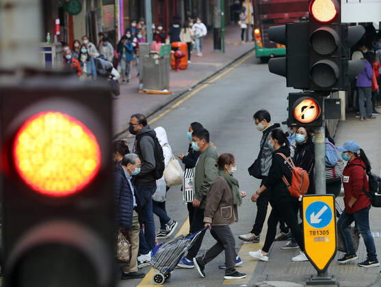 (210117) -- HONG KONG, Jan. 17, 2021 -- People wearing face masks walk across a street in Hong Kong, south China, Jan. 17, 2021. Hong Kong s Center for Health Protection (CHP) reported 55 additional confirmed cases of COVID-19 on Sunday, taking its total tally to 9,557. The new cases included 51 local infections, of which 16 had an unknown origin, according to a CHP press briefing. There were also more than 80 cases tested positive preliminarily. ) CHINA-HONG KONG-COVID-19-CASES(CN) LixGang