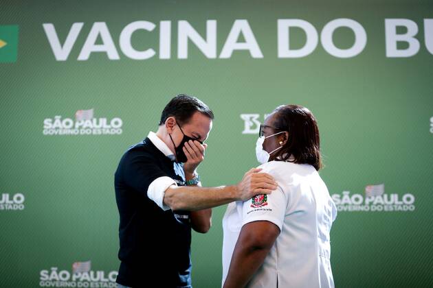 Sao Paulo (Brazil), 17 01 2021.- The governor of Sao Paulo, Joao Doria (L), greets Monica Calazans, a nurse at the Hospital las Clinicas in the capital of Sao Paulo and the first person to receive the vaccine against covid-19, in Sao Paulo, Brazil, 17 January 2021. Brazil, one of the countries in the world most affected by the coronavirus pandemic, applied the first dose of the covid-19 vaccine to the 54-year-old nurse this Sunday in Sao Paulo, at a time when the Latin American giant faces a second wave of the disease. The first dose of the vaccine developed by the Chinese laboratory Sinovac and the Brazilian Butantan Institute was applied just minutes after the approval of its emergency use by the National Health Surveillance Agency (Anvis Copyright: xFernandoxBizerraxJrx AME9923 20210117-637465139664271378