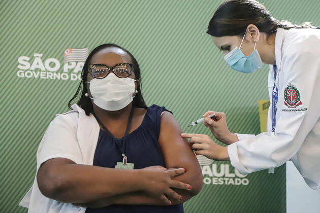 (210117) -- SAO PAULO (BRAZIL), Jan. 17, 2021 -- Brazilian nurse Monica Calazans (L) receives the vaccine against COVID-19 in Sao Paulo, Brazil, on Jan. 17, 2021. Brazilian nurse Monica Calazans became the first Brazilian to be vaccinated against the novel coronavirus on Sunday after Brazilian health authorities approved the emergency use of the vaccines. Brazil s Health Regulatory Agency (Anvisa) unanimously approved on Sunday the emergency use of the CoronaVac vaccine, from the Chinese laboratory Sinovac, as well as the AstraZeneca-University of Oxford vaccine against COVID-19. ) BRAZIL-SAO PAULO-COVID-19-VACCINE RahelxPatrasso 